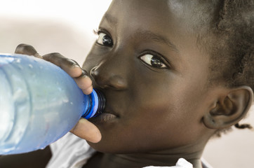 Poverty Symbol: African Black Girl Drinking Heathy Fresh Water. Poverty Symbol in Mali: African...