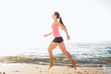 Running woman. Female runner jogging during the sunrise on beach