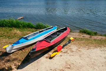 Empty kayaks on the shore of the river.