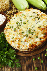 Casserole of pasta with green peas, zucchini and curd