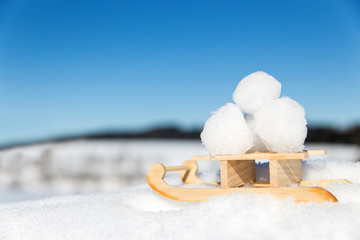 Schlitten mit Schneeb&auml;llen vor blauem Himmel