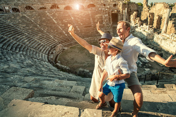 Funny family take a self photo in amphitheatre building