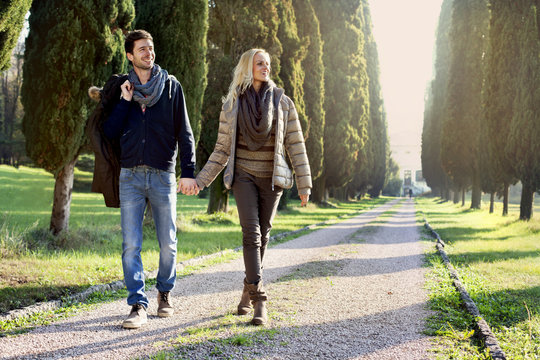 couple walking in the leafy avenue in an autumn day