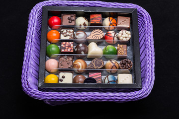 Set of a various chocolate pralines in lavender basket
