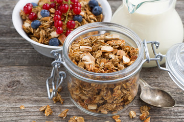 jar with homemade granola, milk and fresh berries, closeup
