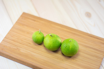 Three lemons on wooden cutting boards.
