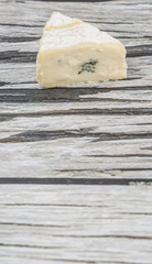 Blue cheese slices over wooden background