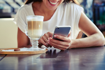 woman using her smartphone in cafe