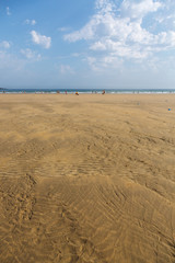 The sandy beach of the Atlantic Ocean. South of France. Basque Country. Hendaye. Blue sky with high clouds and yellow sand. horizon line in the middle. space for inscriptions