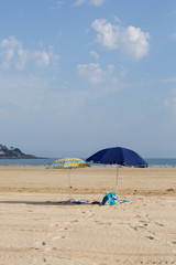 Песчаный пляж атлантического океана. Юг франции. страна баск. андай . Синее небо с большими облаками и желтый песок. линия горизонта посередине. свободное место для надписи. песочный замок