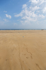 The sandy beach of the Atlantic Ocean. South of France. Basque Country. Hendaye. Blue sky with high clouds and yellow sand. horizon line in the middle. space for inscriptions