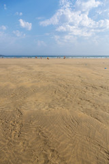 The sandy beach of the Atlantic Ocean. South of France. Basque Country. Hendaye. Blue sky with high clouds and yellow sand. horizon line in the middle. space for inscriptions