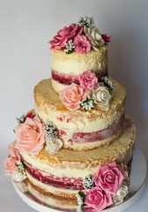 Wedding cake. Naked handmade cake rustic, decorated with roses.