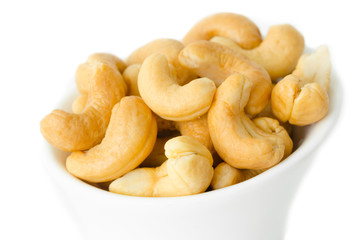 Cashew nuts in a white bowl.