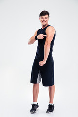 Fototapeta premium Athletic man pointing finger at his muscles