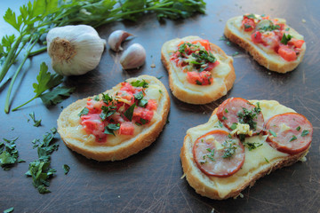 Bruschettas with fresh tomatoes, cheese, sausage, garlic and herbs