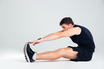 Fototapeta na wymiar Portrait of athletic man doing stretching exercises