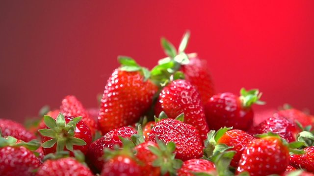 Fresh ripe perfect strawberry over red background. Food concept