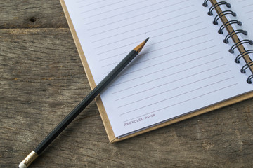 notebook recycling , pencil  on wooden