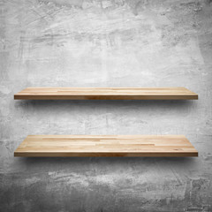 Empty wooden shelves on bare concrete wall background