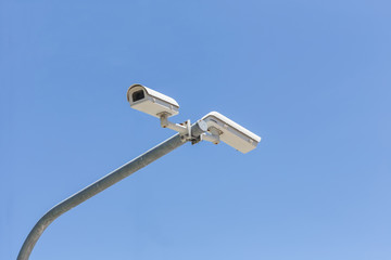 Two security camera on blue sky