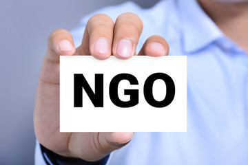 NGO letters (or Non-Governmental Organization) on the card shown by a man