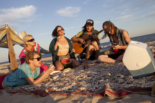 Friends playing music together on a beach