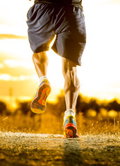 sport man strong legs in off road trail running at amazing summer sunset healthy lifestyle