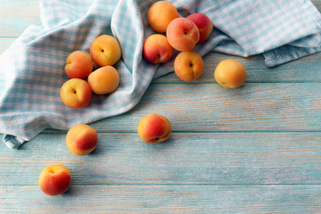 Ripe apricots with napkin on wooden table close up