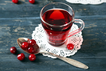 Sweet homemade cherry juice on table, on color wooden background