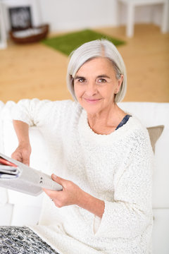 moderne seniorin liest zuhause die tageszeitung