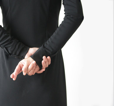 Rear view of a woman with fingers crossed behind back