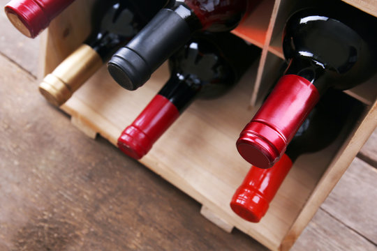 Box with wine bottlenecks on the table, close up.