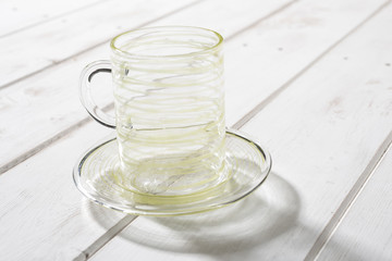 Crystal Mug and Saucer Streaked with Yellow on Wooden Panel