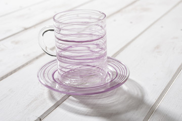 Crystal Mug and Saucer Streaked with Purple on Wooden Panel