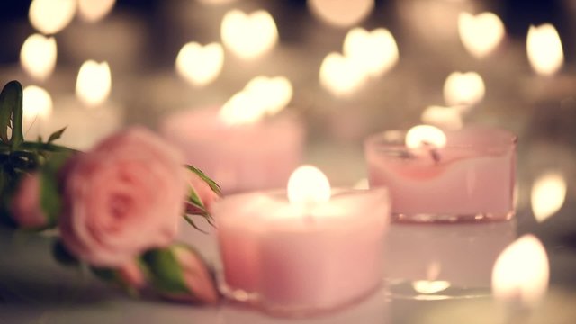 Beautiful burning candles and rose flower over scene. Romantic dinner. Valentine