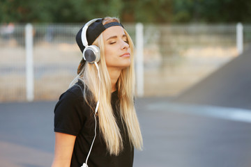 Young woman with earphones outside