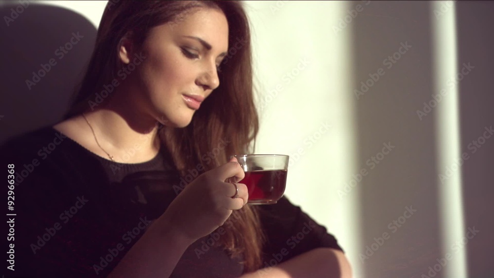 Wall mural Young beauty romantic woman drinking hot tea or coffee in morning light.