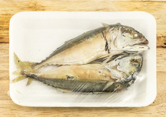mackerel steamed in foam white tray on wooden background