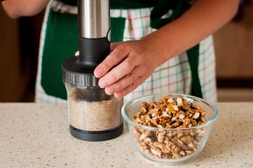 A Woman Chopping Walnuts in a Food Processor