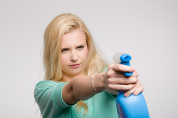 Junge blonde Frau mit Reinigungsmittel