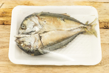 mackerel steamed in foam white tray on wooden background