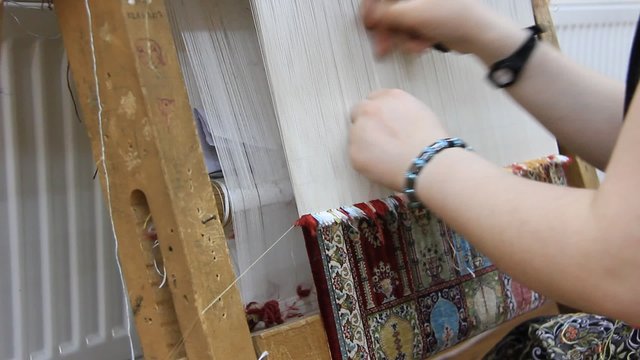Carpet weaving. Turk woman making a silk carpet