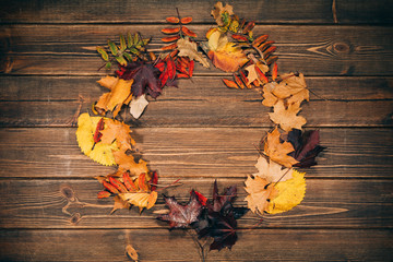 Background with wooden table and autumnal leaves