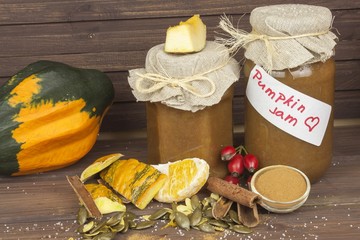 Domestic production pumpkin marmalade. Sweet children's menu. Preserving domestic products. Processing pumpkins, autumn harvest time. Pumpkin jam in glass jar with ingredients.
