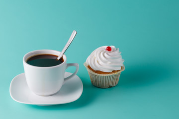 colorful pink cupcake on aquamarine background with coffee cup