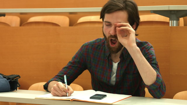 Tired student taking down notes