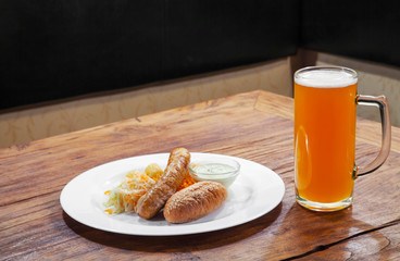 sausages with vegetables and mug with beer