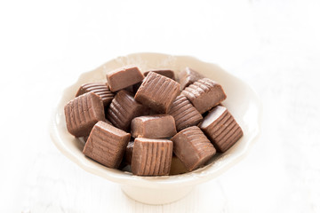 Chocolate caramel bonbons in the bowl,selective focus