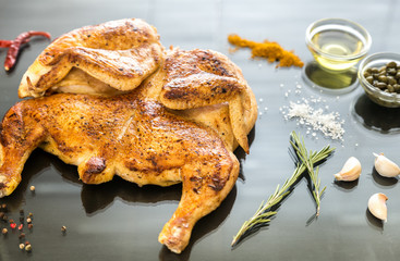 Grilled chicken with ingredients on the dark wooden background